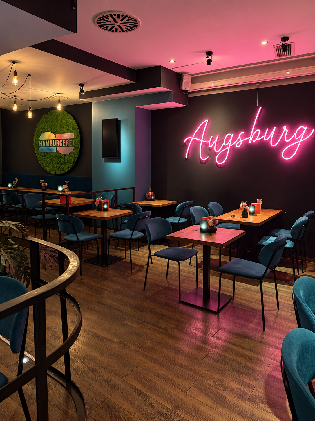 Gastraum mit pinkem Augsburg-Neonschriftzug
